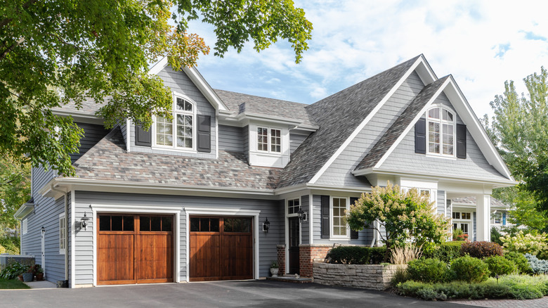 Light gray home with wood garage doors and gray trim