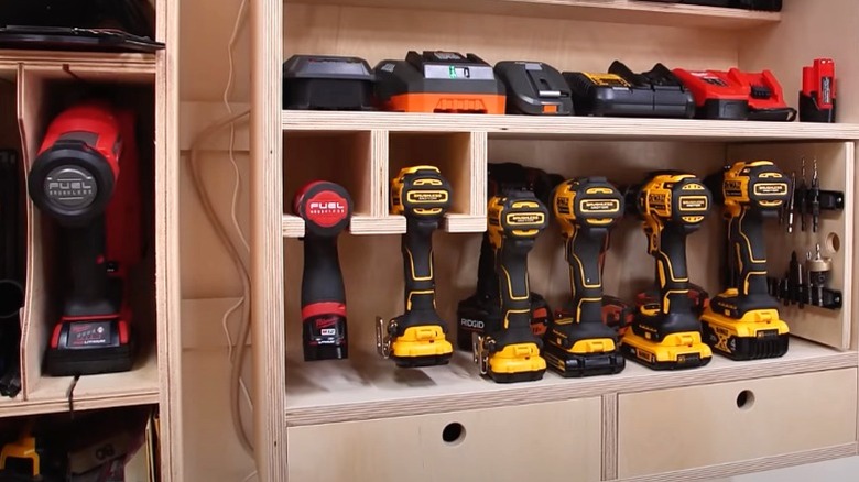 French cleat drill charging station with battery charging shelf and lineup of six drills