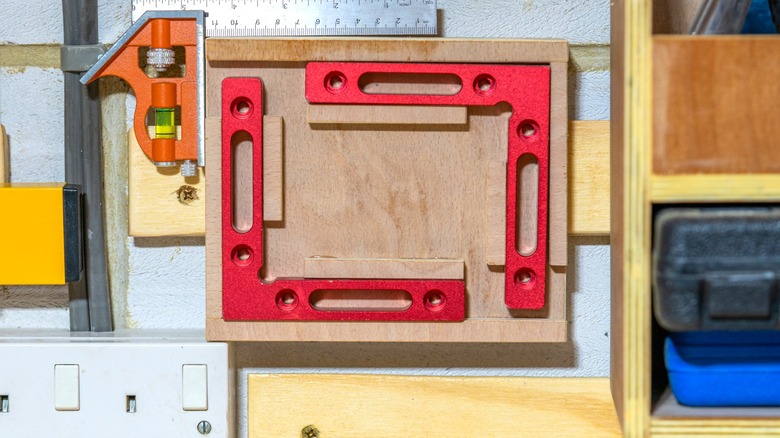 squares on French cleat storage holder against masonry wall