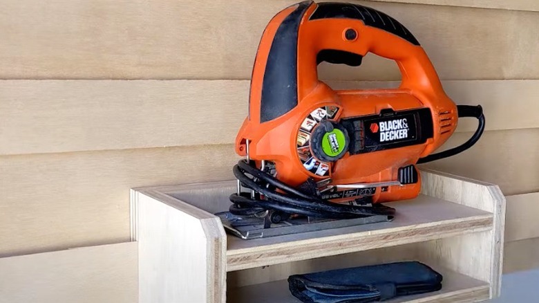 Black & Decker jigsaw with cord wrapped around it on French cleat shelf