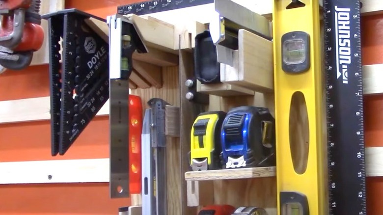 squares, levels, and tape measures on hanging French cleat wall rack