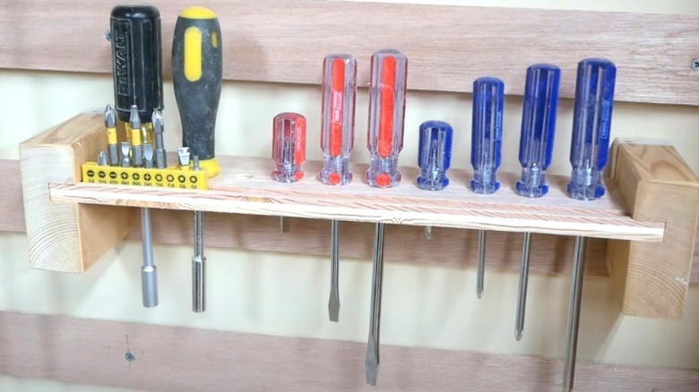 French cleat wall rack holding assorted screwdrivers and bits