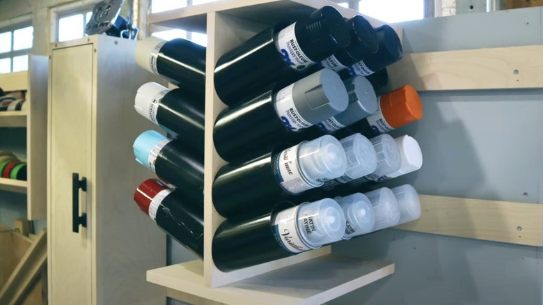 spray paint can holder on French cleat wall in garage