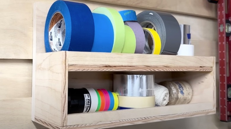 two-tiered French cleat shelving holding various tape rolls