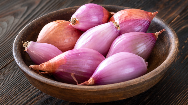 pink shallots in wooden bowl