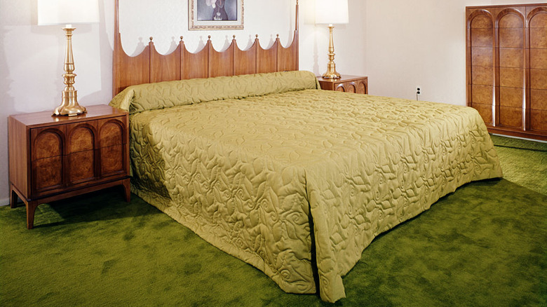 bedroom with green carpet and bedding