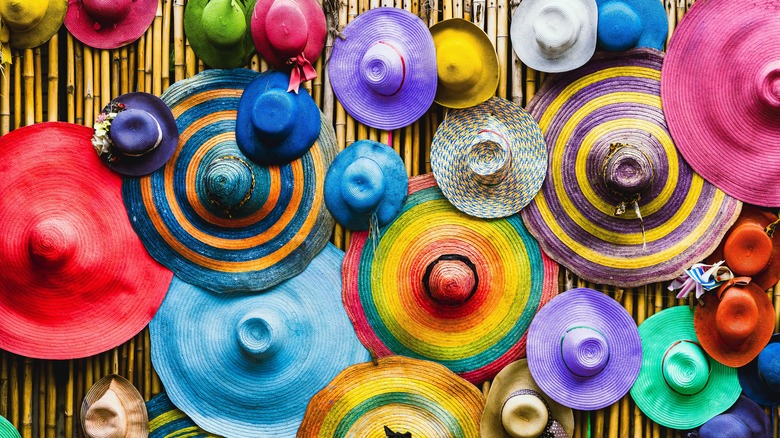 colorful hats on bamboo wall