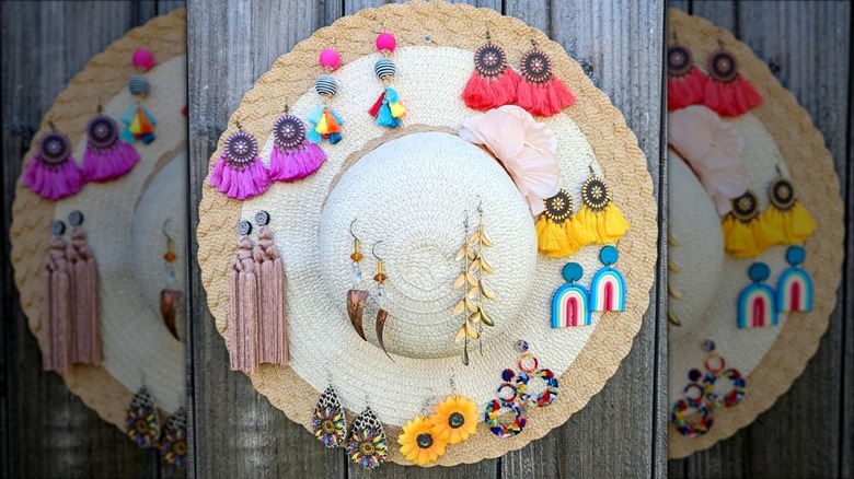 straw hat holding dangly earrings