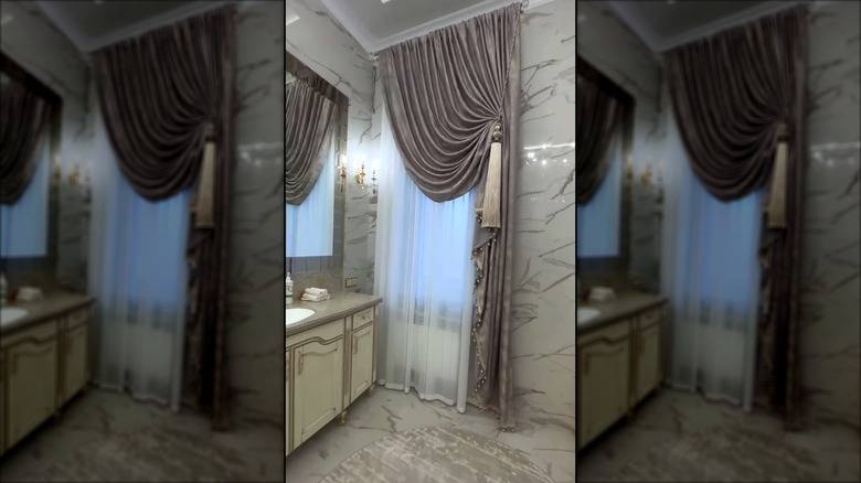 Luxurious bathroom with floor to ceiling drapes