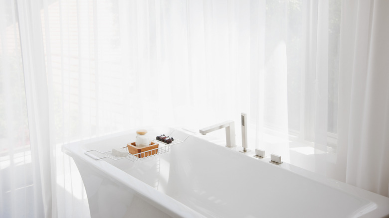 Luxurious bathroom with white curtains in front of the windows