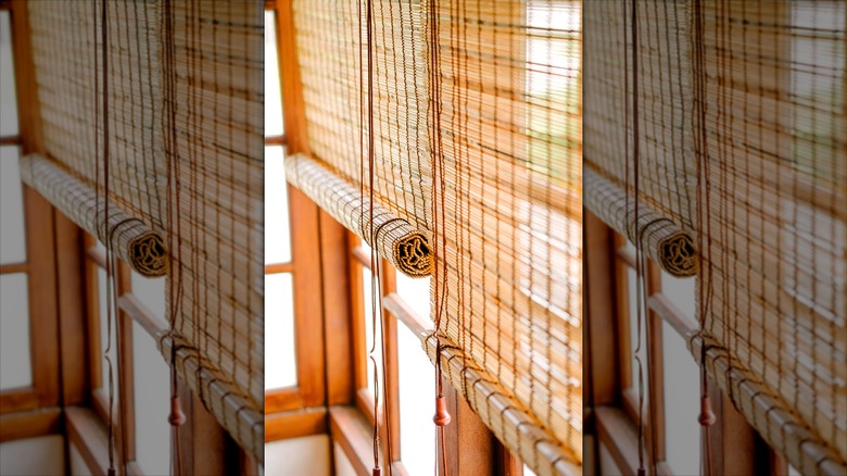 Bamboo window shades partially rolled down