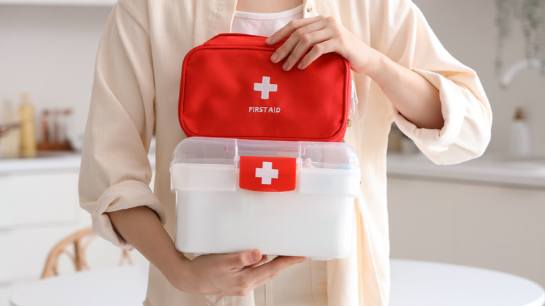 A person holding first aid kits in their hands