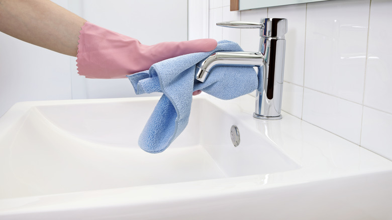 Person cleaning faucet