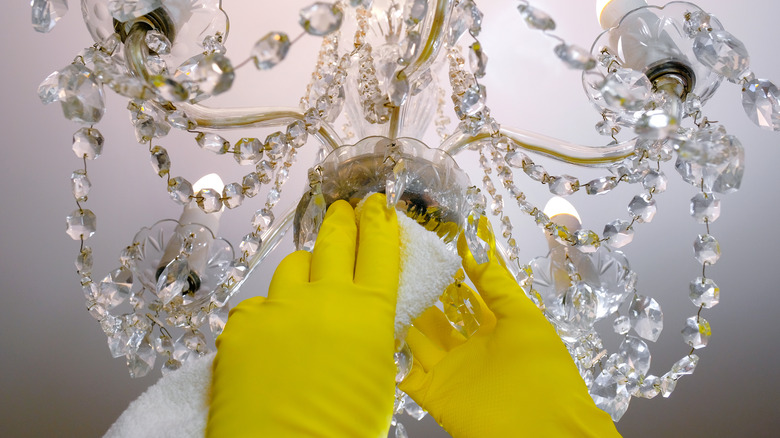 Person cleaning chandelier