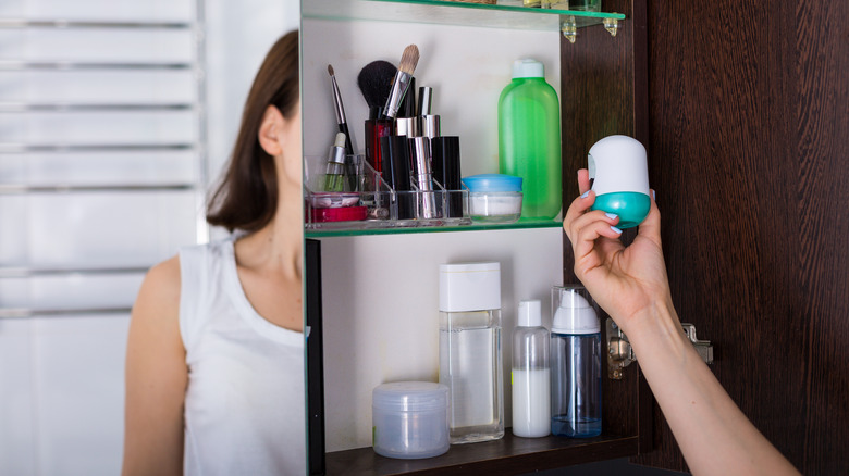 woman holding product from medicine cabinet