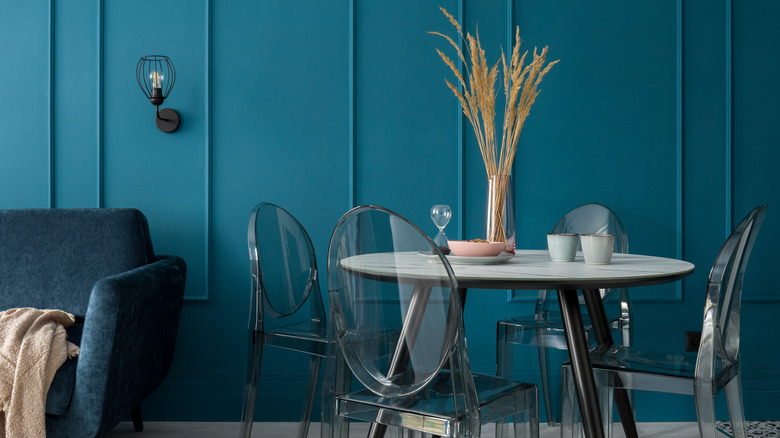 clear chairs in blue room