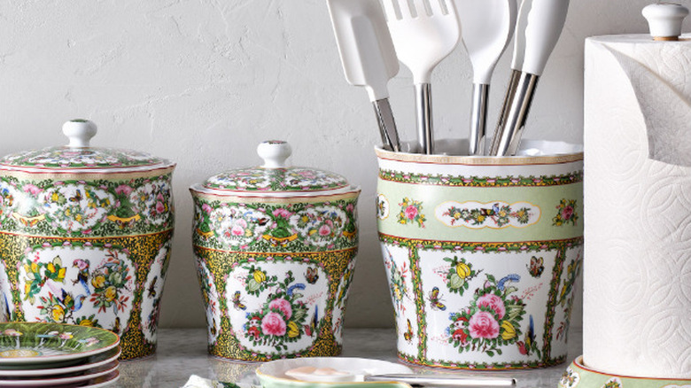 A floral utensil container holds utensils alongside matching pots