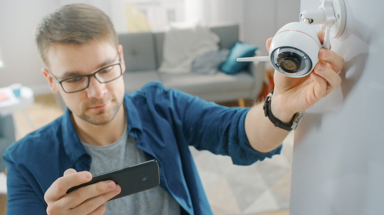 man installing security camera