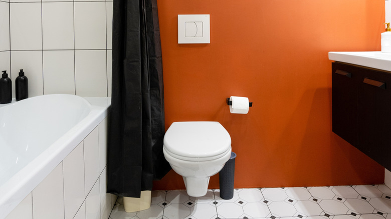 Orange accent wall behind toilet