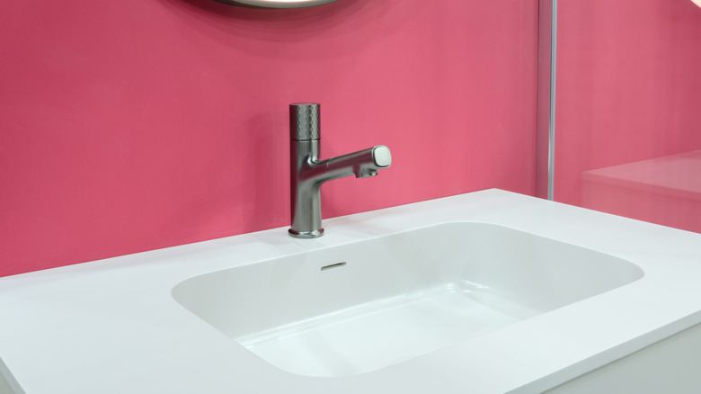 Vibrant pink accent wall behind sink