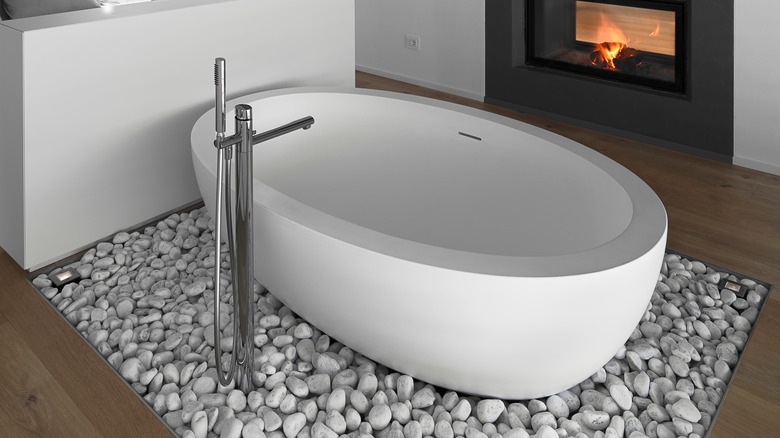 gray pebbles around white bathtub