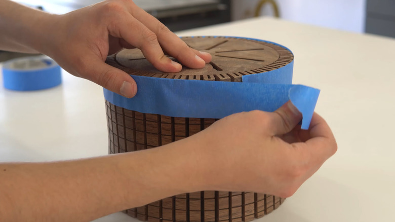 Measuring the circumference of a lamp with painter's tape