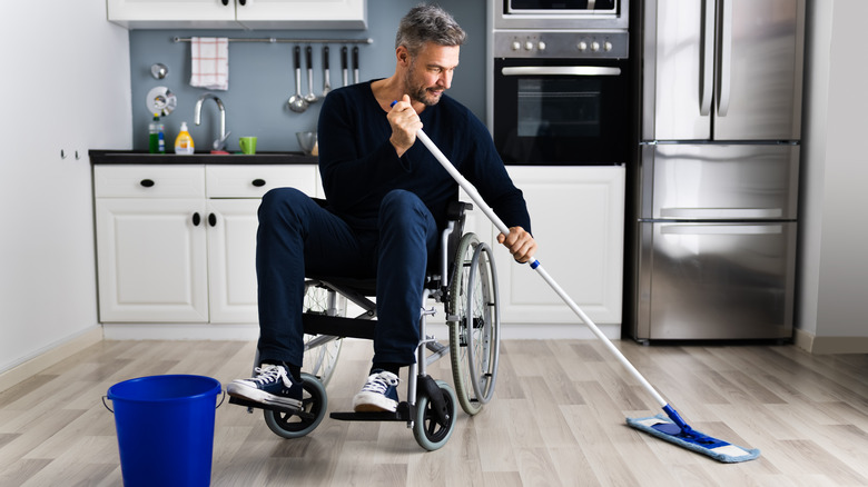 Person in wheelchair cleaning kitchen