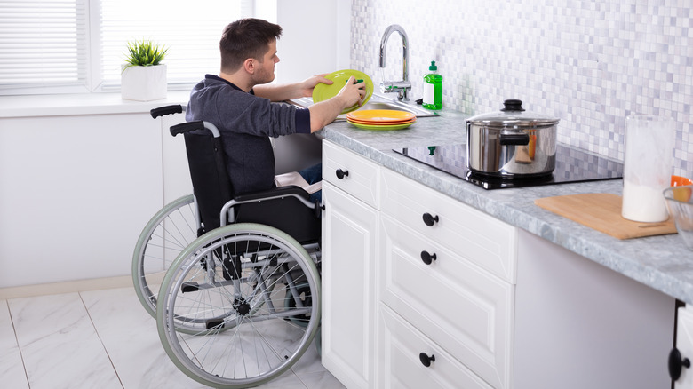 Person in wheelchair washing dishes