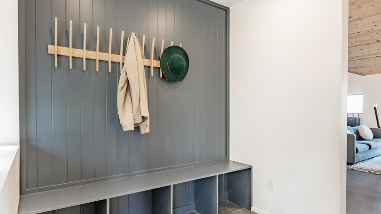 Gray panels on entryway wall with wooden coat hanger