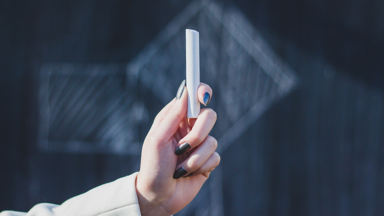 Someone holding a piece of white chalk