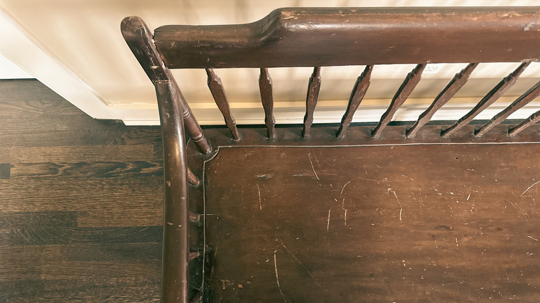 A wooden bench with scratch marks on the seat.