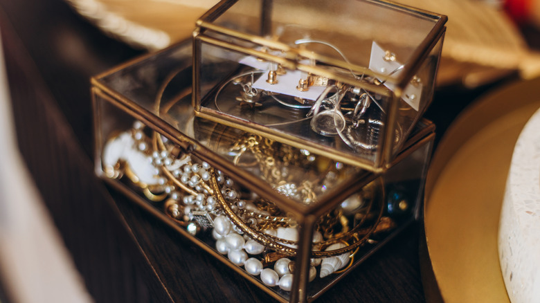 Two glass boxes filled with tangled jewelry.