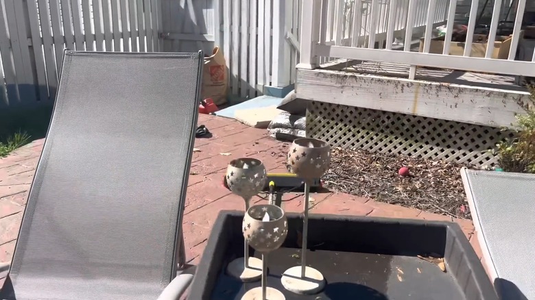 Vintage candle holders on a table between two lounge chairs