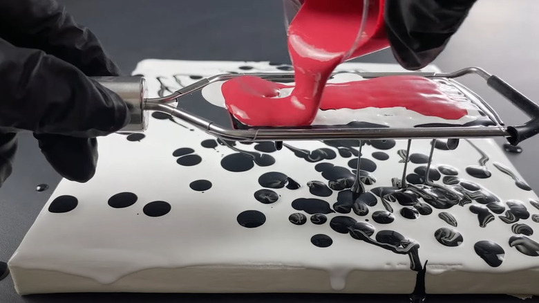 pouring red paint over grater