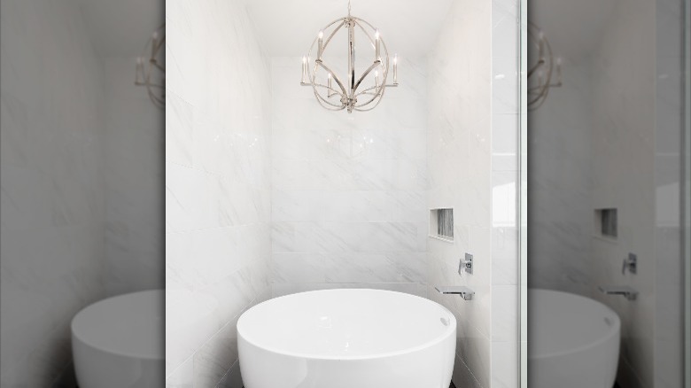 silver light fixture above bathtub