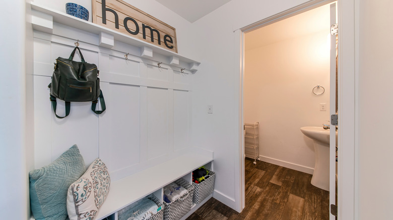 white mudroom bench with hooks