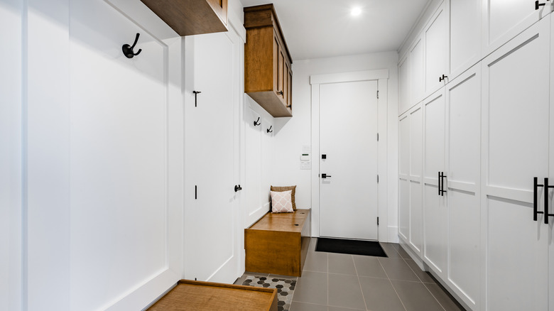 wooden benches in white mudroom