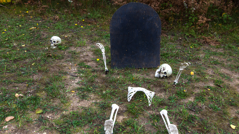 black tombstone with skeleton pieces