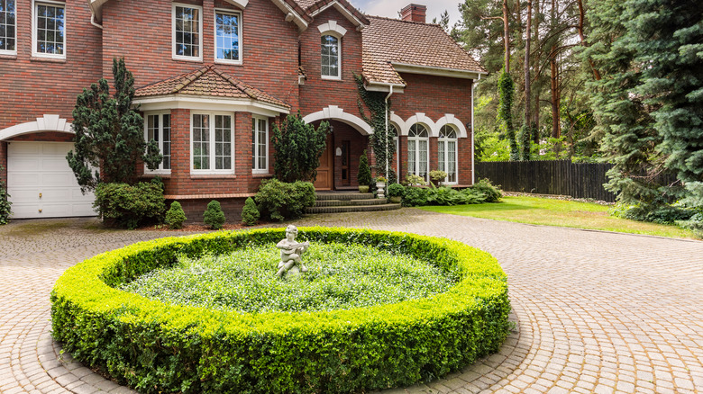 round hedge in brick driveway