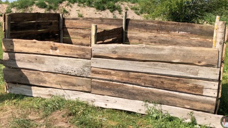 A wooden compost bin made from old fence posts