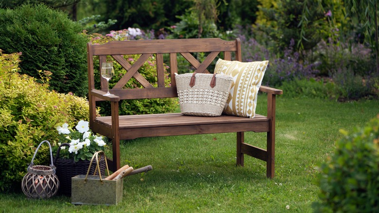 A pretty wooden bench with pillows in backyard garden