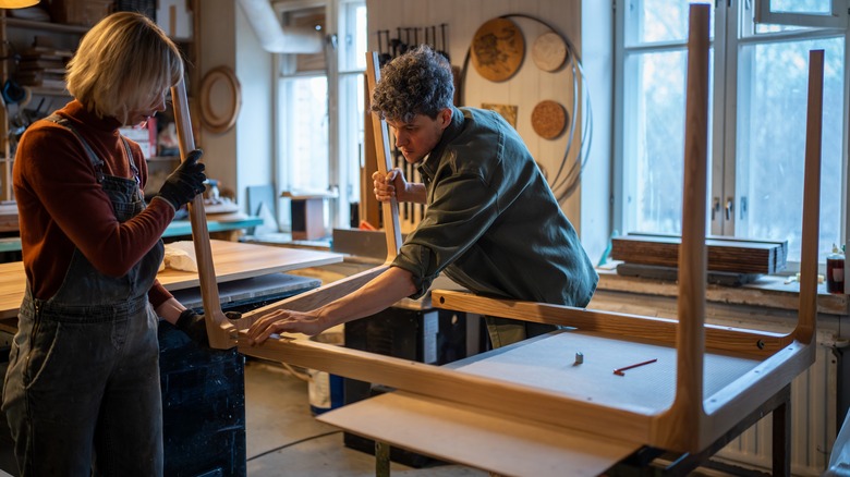 people holding wood table legs