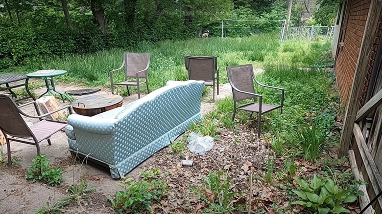 overgrown lawn littered with furniture 