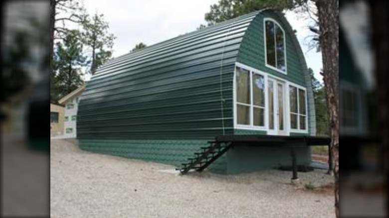 green arched cabin in woods