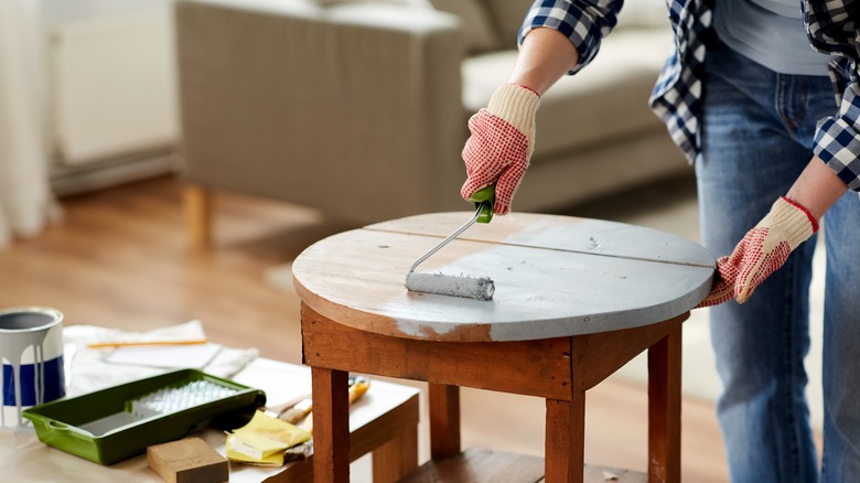 Hands painting a table