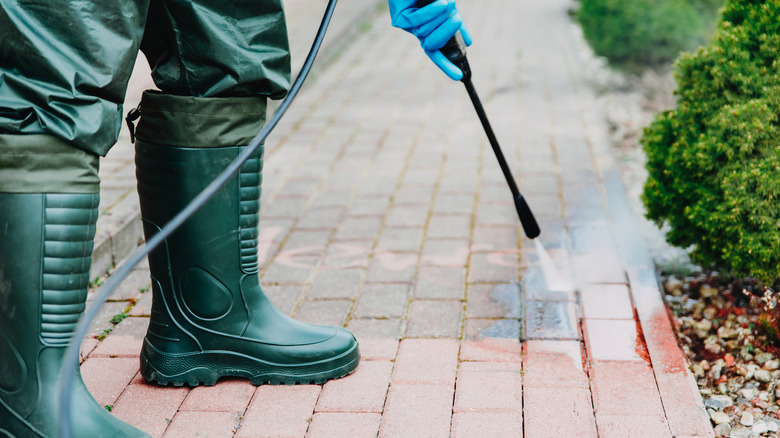 man power washing walkway