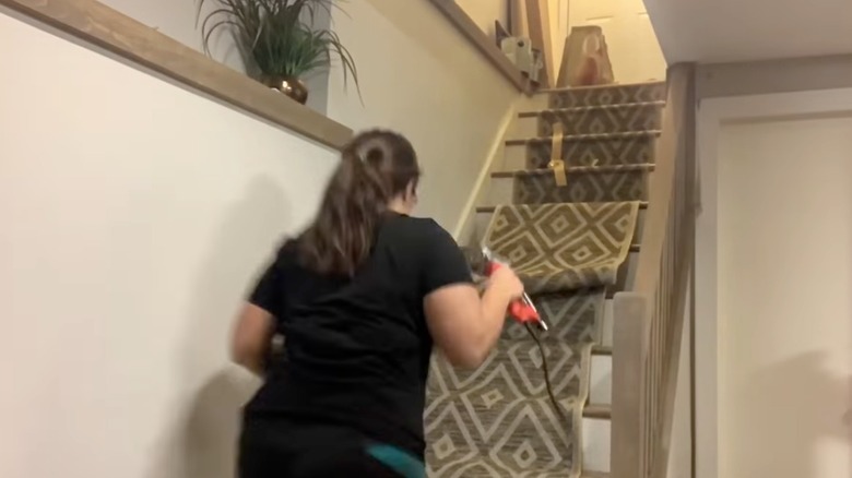 Woman installing stair runner