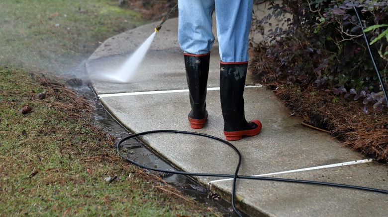 Person power washing walkway