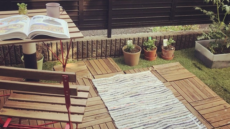 Wooden chair and table with book and coffee mug on patio