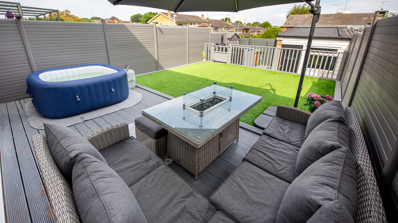 Blue inflatable hot tub with gray furniture on patio